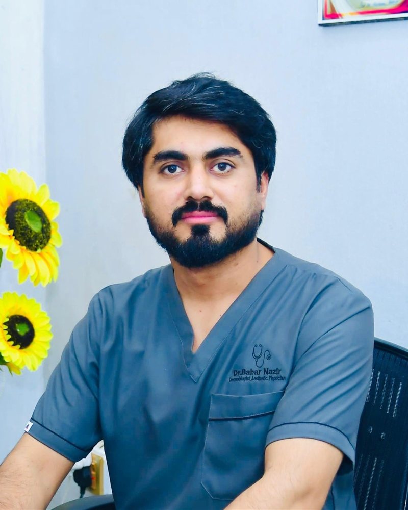 Dr. Babar Nazir, consultant dermatologist, at his desk in the clinic